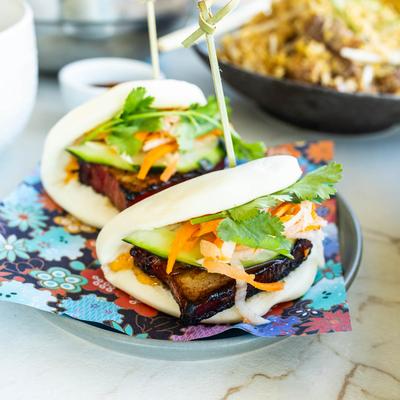 Two pork belly bao buns on a plate