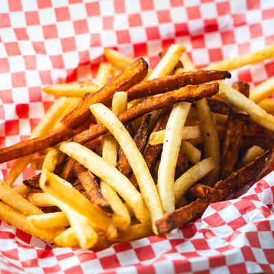 Regular and sweet potato fries on red-and-white checkered paper.