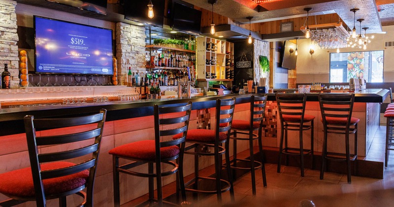 Interior, bar area, bar with padded stools, large TV and drink shelves behind the bar