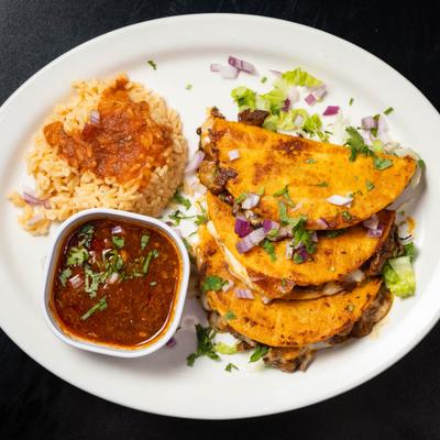 Quesabirria tacos served with Mexican rice and a side of savory beef broth.