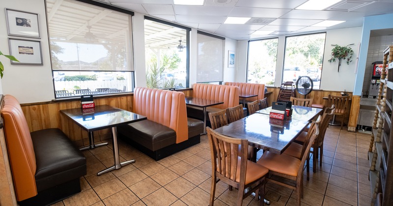 Bright diner interior with tan booths and wooden tables