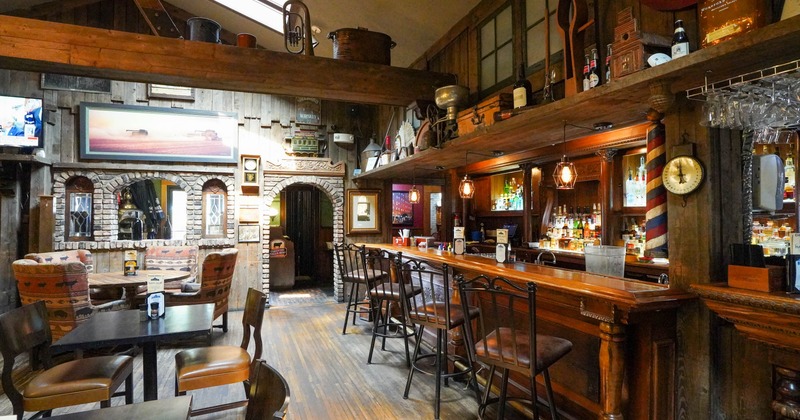 Interior, bar area, wooden top counter with stools on the right, seating area on the left