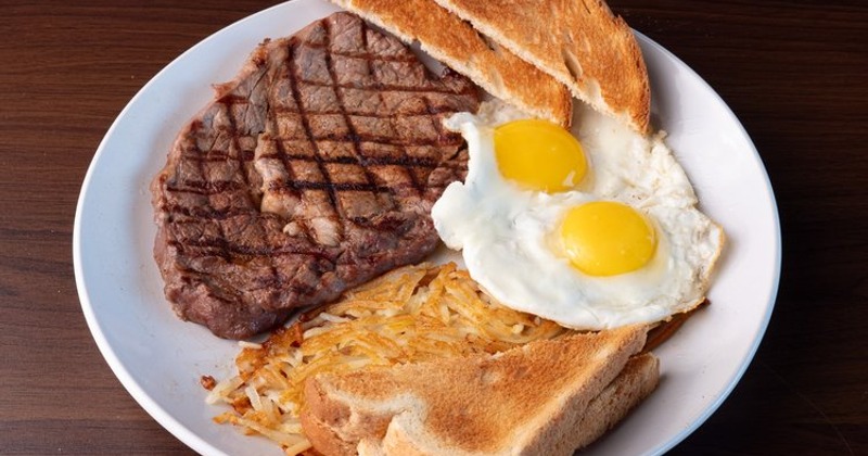 Steak and eggs served with hash browns and toasted bread