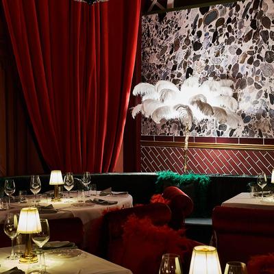 Tables set with plates, lamps, wine glasses and wall decorations in the background.