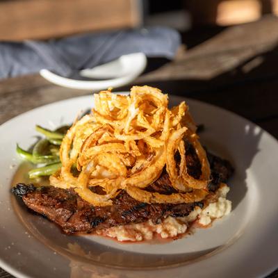 Grilled skirt steak, with onion rings, mashed potatoes, and sauteed spinach.