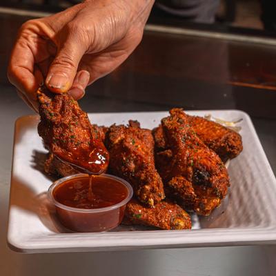 A hand dipping the Raven Wings.