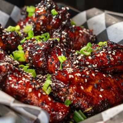 Glazed chicken wings topped with scallions and sesame seeds.