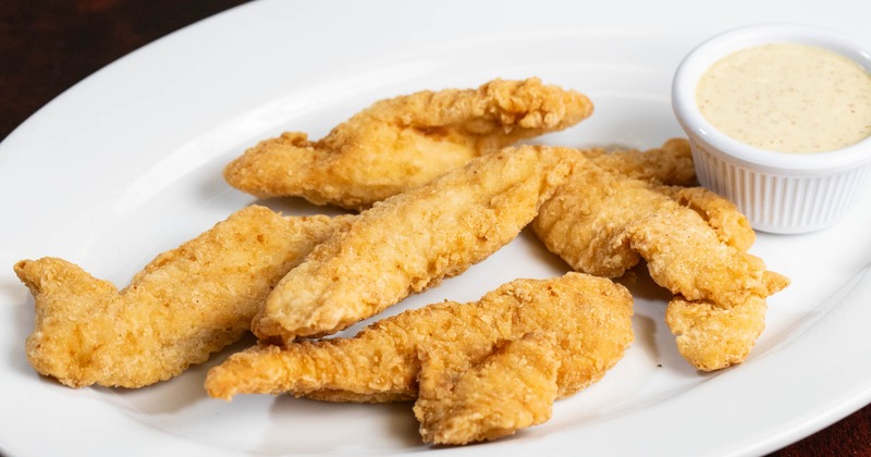 Chicken fingers served with a dipping sauce