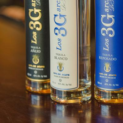 Three tequila bottles on a table.