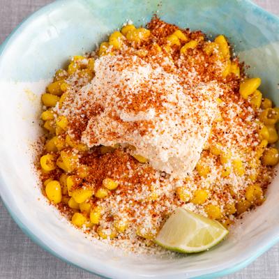 Corn cup topped with cheese seasoning and lime.