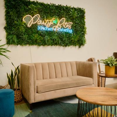 Interior, lounge by a wall with faux greenery decoration.