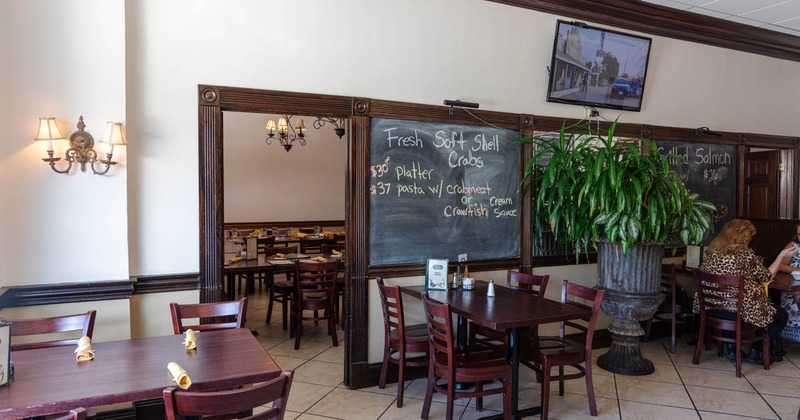 Interior, seating area with big plant and a blackboard on the wall