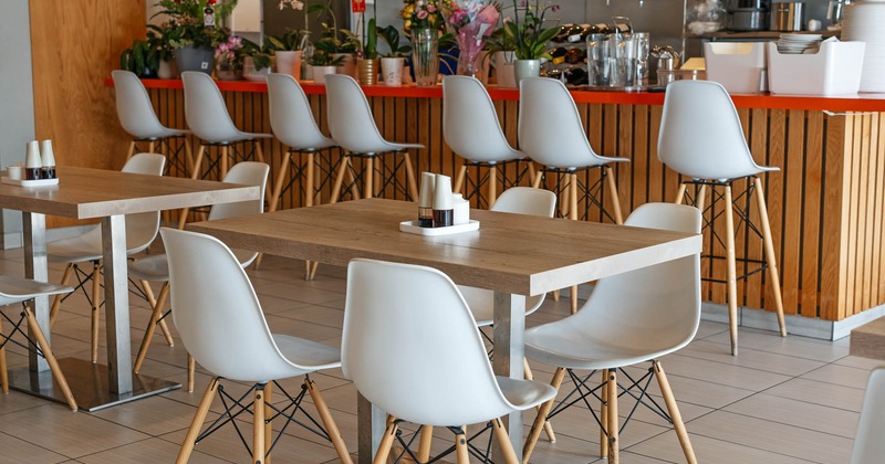 Interior, tables and chairs with bar behind