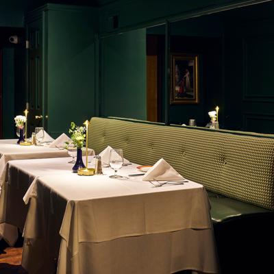 Elegant table setting beside a green banquette.