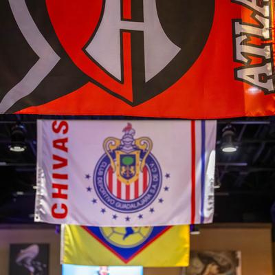 Colorful soccer club flags hanging from the ceiling.