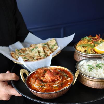 Hands holding a tray with various foods.