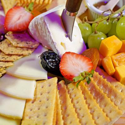 Cheese board served with crackers and fruits.