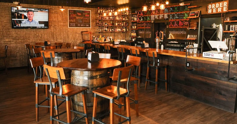 Interior, barrel tables with bar chairs near a bar