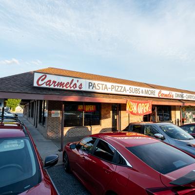 Restaurant storefront with parked cars outside.
