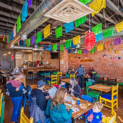 Colorful dining room with hanging baners and people seated.