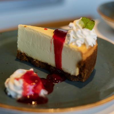 Cheesecake with whipping cream on the side.