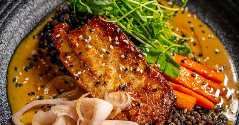 Pork belly in sauce, served with lentils, onion, carrots and microgreens