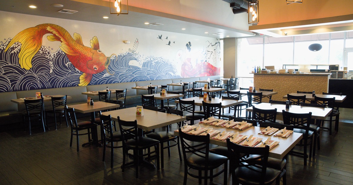 Interior, vibrant mural, wooden tables with black chairs, and pendant lighting