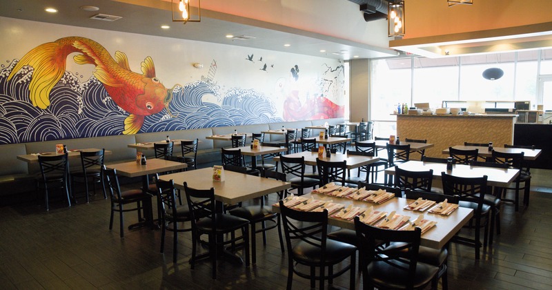 Interior, vibrant mural, wooden tables with black chairs, and pendant lighting