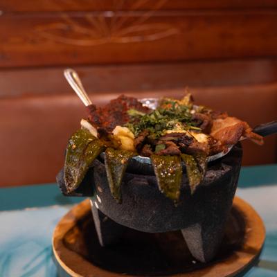 Molcajete with variety of grilled meats and vegetables.