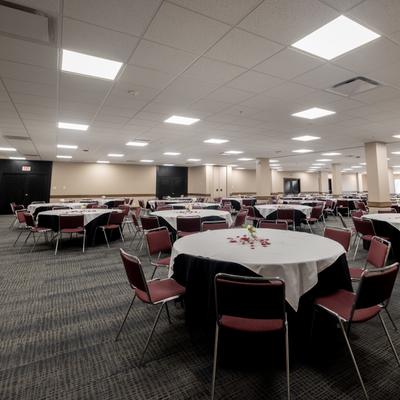 A large hall, tables and chairs set for guests.