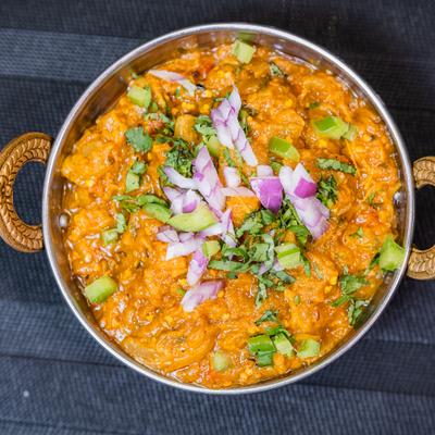 Curry dish topped with herbs and diced onions.