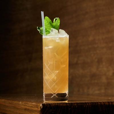 Daily Ration, orange cocktail in a tall glass with mint garnish.