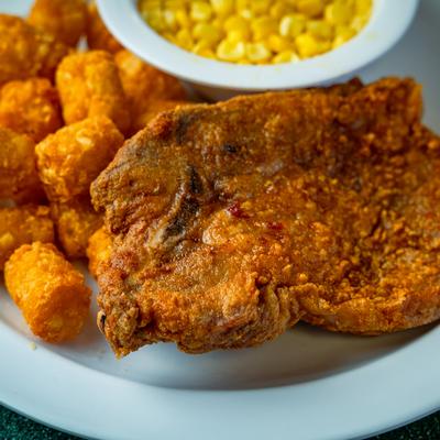 Fried Pork Chops with tater tots and corn.