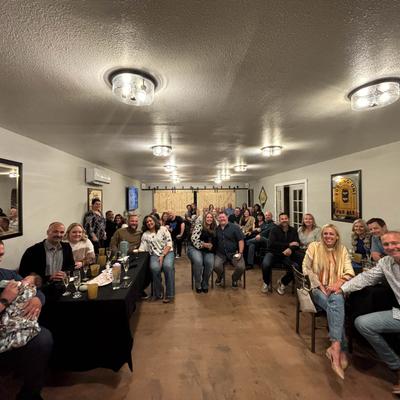 People seated in a well-lit room, enjoying drinks.
