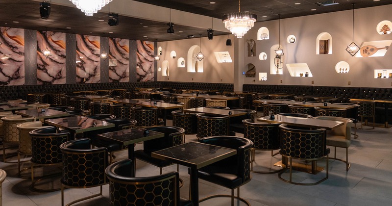 Dining room featuring prominent honeycomb-patterned chairs and crystal chandeliers