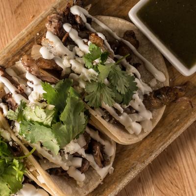 Duck Confit Tacos served with cup of poblano chile sauce.