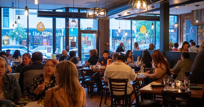 Dining area full of guests chatting and enjoying their food and drinks