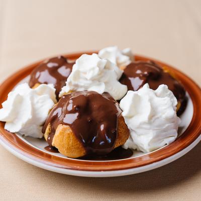 Cream puffs drizzled in chocolate sauce.