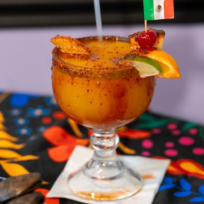 Mangonada margarita with fruit garnish and a Mexican flag toothpick.