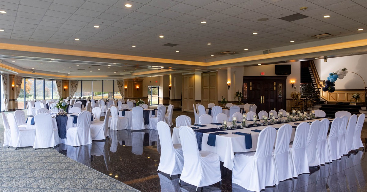 Interior, wedding venue, decorated white cloth tables with chairs, ready for guests