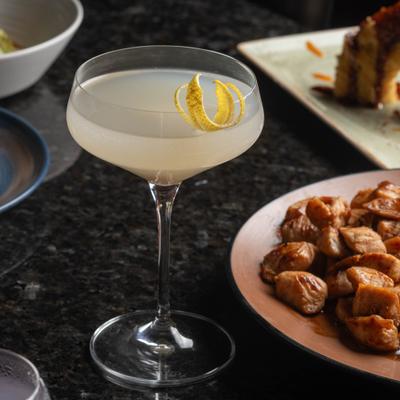 Pearl Drop cocktail served in a coupe, garnished with lemon peel.