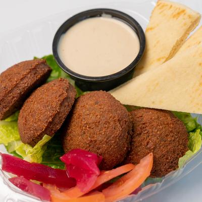 Falafel with sides of a sauce, pita bread and pickled veggies