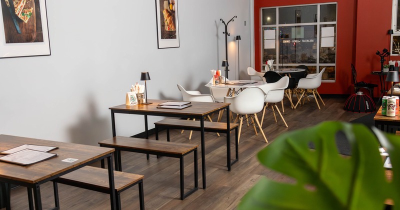 A cafe interior with wooden tables and white chairs