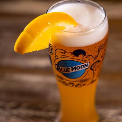 A glass of beer with a lemon slice on the rim.