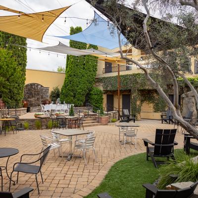 Spacious outside seating area, trees, sun shades, string lights