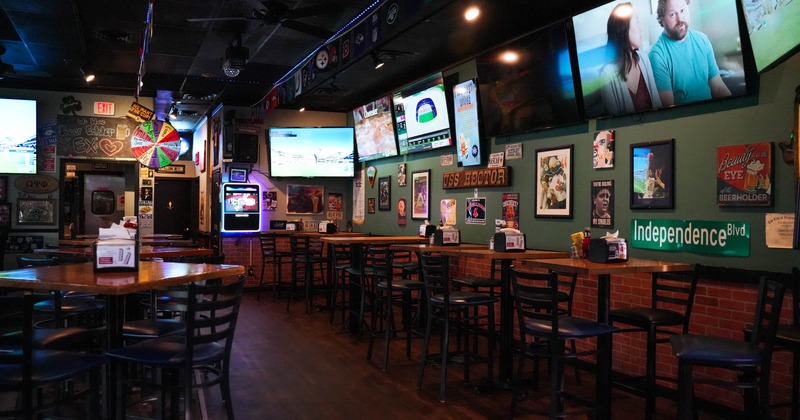 Interior, tables and chairs, tv screens on the wall