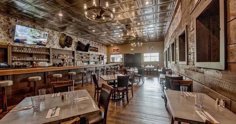 Interior, all-wooden dining area with a bar and chandeliers