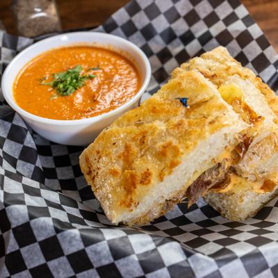 Philly grilled cheese served with tomato soup.