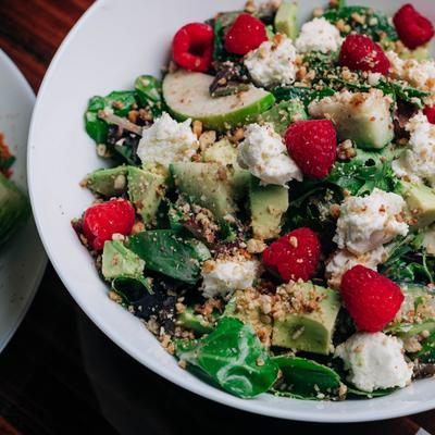 Salad with mixed greens, nuts, apples, cucumber, avocado, goat cheese, and raspberries.