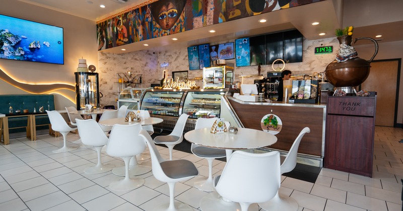 Interior, diner tables, armchairs, food counter behind